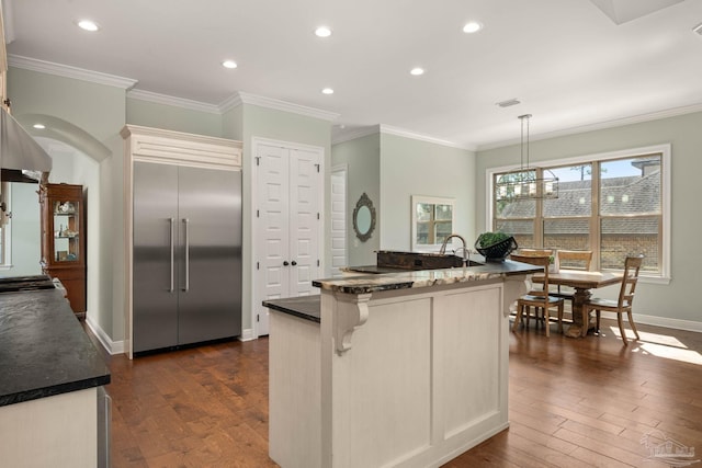 8901 Salt Grass Dr, Pensacola, FL 32526 - kitchen with a breakfast bar, stainless steel built in fridge, ornamental molding, and dark wood finished floors