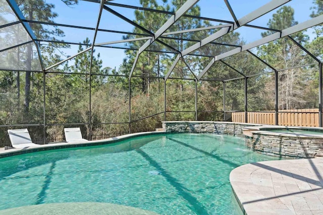 8901 Salt Grass Dr, Pensacola, FL 32526 - view of swimming pool featuring glass enclosure, a pool with connected hot tub, and a wooded view