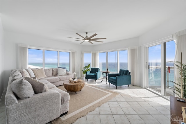 tiled living room featuring a water view, a wealth of natural light, and ceiling fan