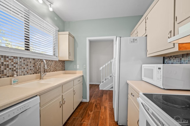 kitchen with white appliances, dark wood finished floors, backsplash, light countertops, and a sink