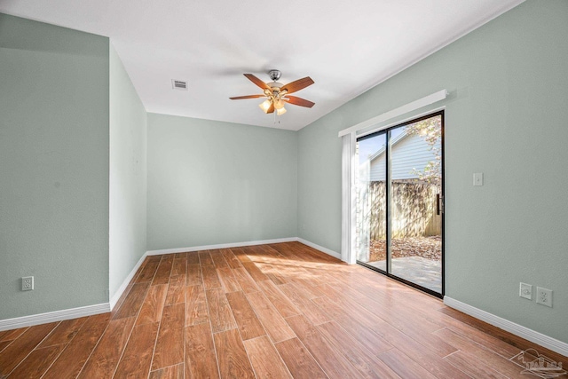 empty room with a ceiling fan, visible vents, baseboards, and wood finished floors