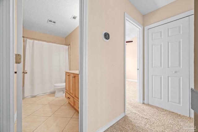 full bath with visible vents, toilet, tile patterned floors, a textured ceiling, and vanity