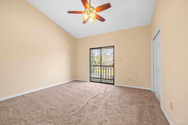 spare room featuring vaulted ceiling, carpet, a ceiling fan, and baseboards
