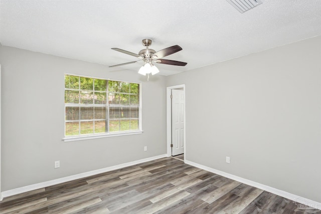 empty room with a textured ceiling, ceiling fan, and wood-type flooring