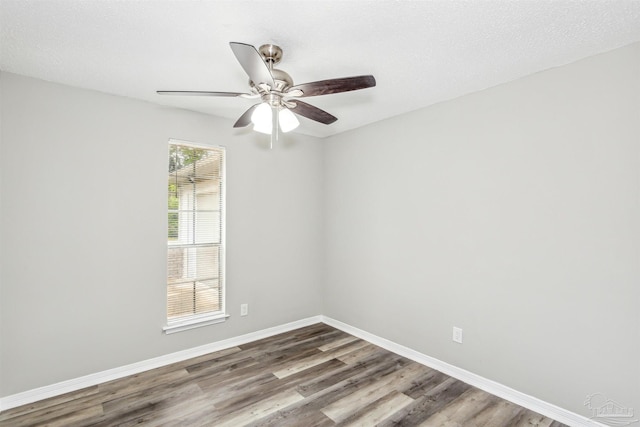 unfurnished room featuring plenty of natural light, wood-type flooring, and a textured ceiling