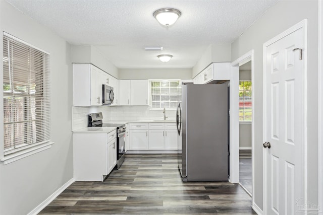 kitchen with white cabinetry, appliances with stainless steel finishes, and a wealth of natural light