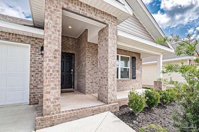 5805 Guinevere Ln, Milton, FL 32583 - doorway to property featuring a porch, brick siding, and a garage