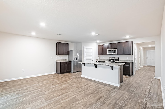 5805 Guinevere Ln, Milton, FL 32583 - kitchen with appliances with stainless steel finishes, a kitchen bar, light wood-style floors, baseboards, and recessed lighting