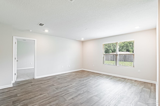 5805 Guinevere Ln, Milton, FL 32583 - empty room with wood finished floors, a textured ceiling, baseboards, and recessed lighting