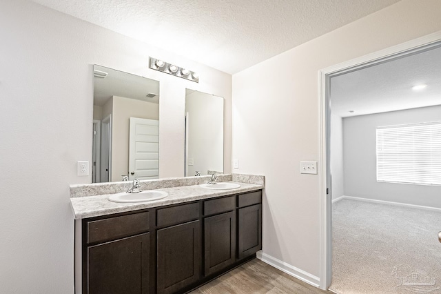 5805 Guinevere Ln, Milton, FL 32583 - bathroom with double vanity, a textured ceiling, and baseboards