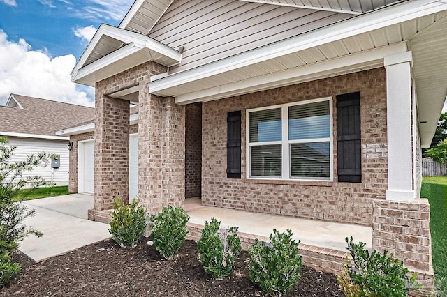 5805 Guinevere Ln, Milton, FL 32583 - doorway to property featuring a porch, an attached garage, and brick siding