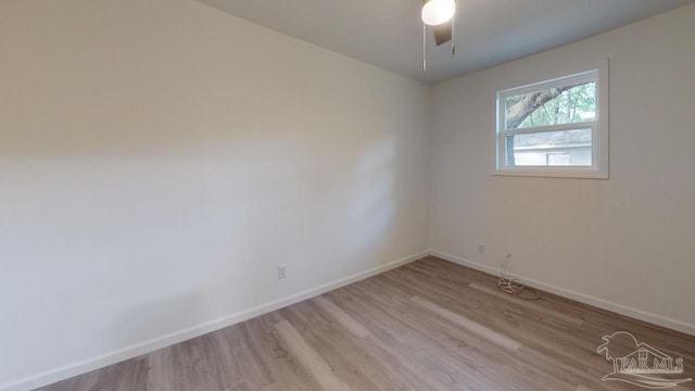 unfurnished room with light wood finished floors, a ceiling fan, and baseboards