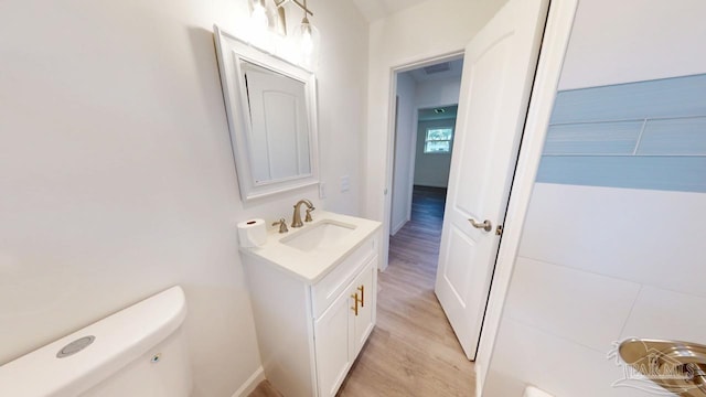 bathroom featuring visible vents, toilet, vanity, and wood finished floors