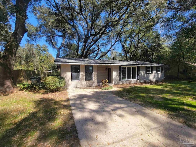 ranch-style home with a front yard and fence