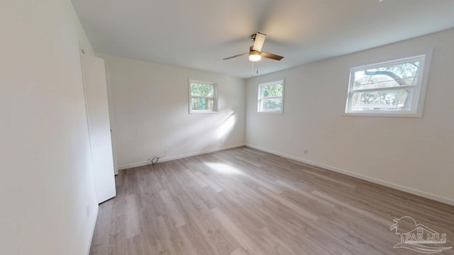 empty room featuring ceiling fan, baseboards, and light wood-style floors