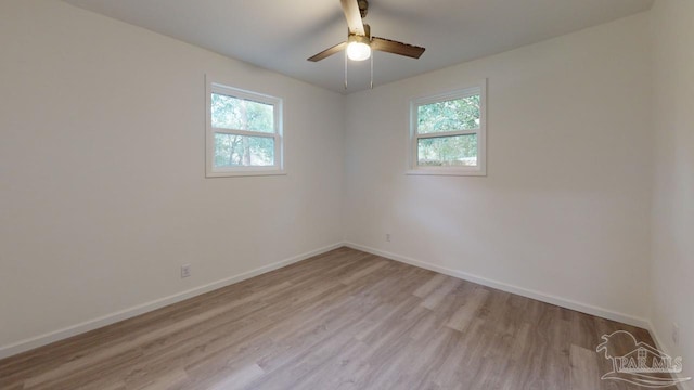 empty room with baseboards, a healthy amount of sunlight, and wood finished floors