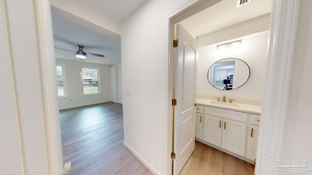 bathroom featuring visible vents, wood finished floors, baseboards, ceiling fan, and vanity