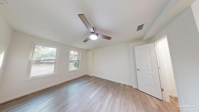 unfurnished room featuring visible vents, light wood-style flooring, a ceiling fan, and baseboards