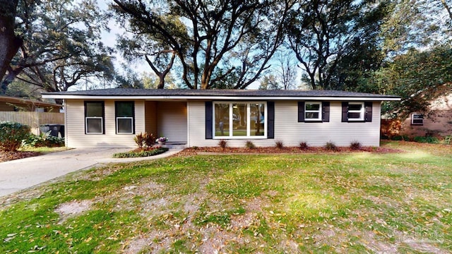 ranch-style house featuring a front lawn and fence