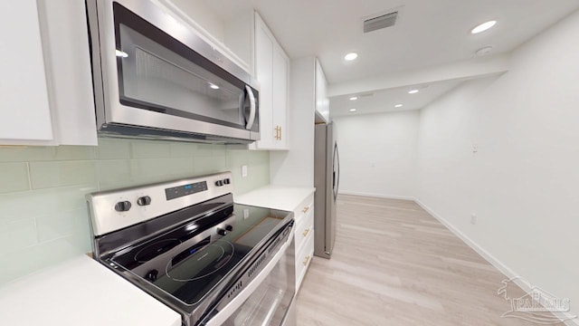 kitchen with light countertops, white cabinets, tasteful backsplash, and stainless steel appliances