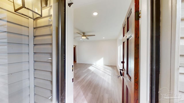 hallway with recessed lighting, light wood-type flooring, and baseboards