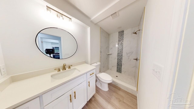 full bath with visible vents, toilet, wood finished floors, a marble finish shower, and vanity