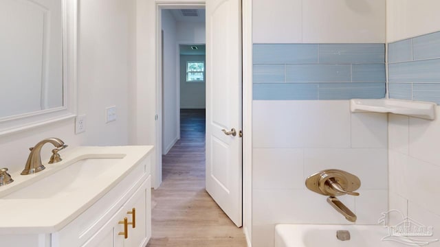 full bathroom featuring visible vents, vanity, bathtub / shower combination, and wood finished floors