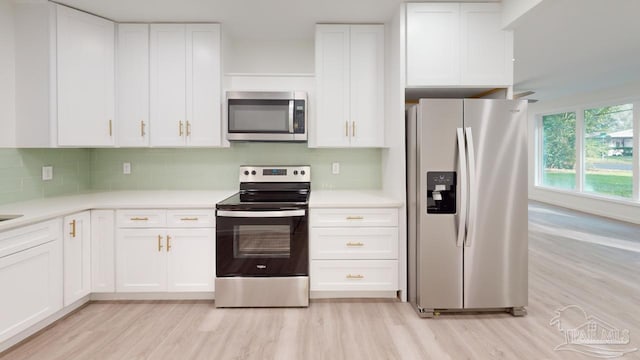 kitchen with white cabinetry, light wood-style floors, appliances with stainless steel finishes, and light countertops