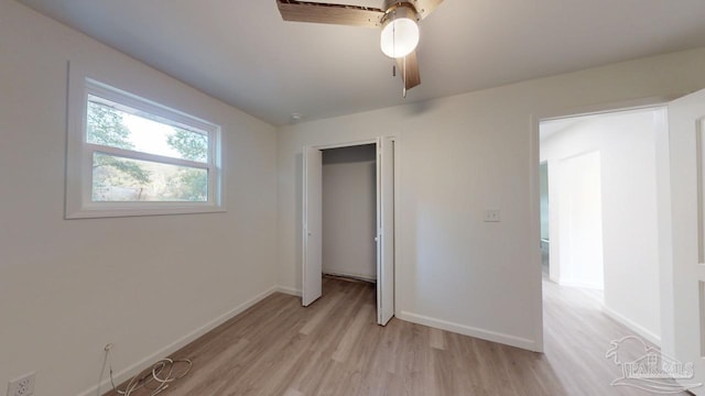 unfurnished bedroom with light wood-style flooring, baseboards, a closet, and ceiling fan