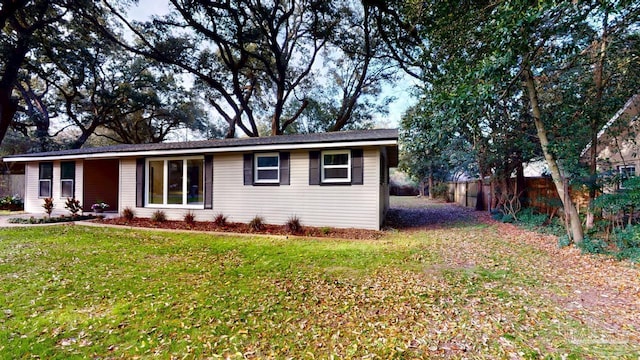 ranch-style house featuring a front yard and fence