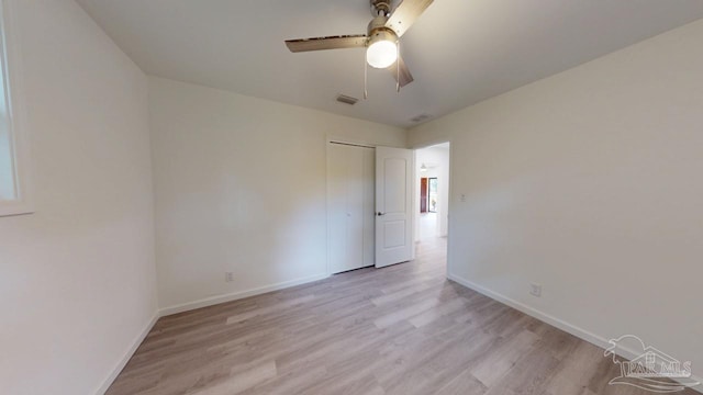 spare room featuring light wood-style flooring, baseboards, visible vents, and ceiling fan