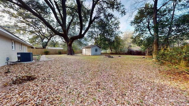 view of yard featuring an outbuilding, cooling unit, a storage shed, and a fenced backyard