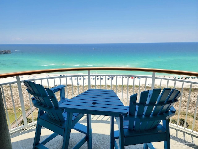 balcony with a water view and a view of the beach