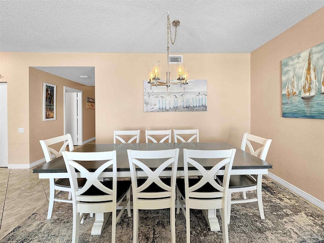 dining room with a textured ceiling and a notable chandelier