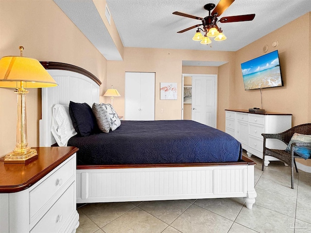 tiled bedroom featuring ceiling fan and a textured ceiling