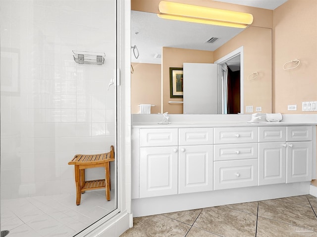 bathroom featuring vanity, a tile shower, and tile patterned floors