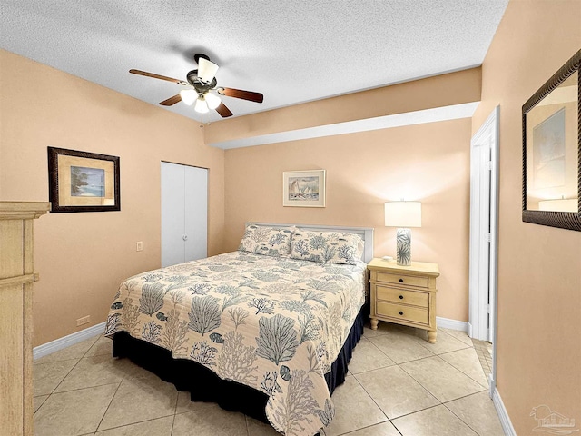 bedroom with ceiling fan, a closet, a textured ceiling, and light tile patterned floors