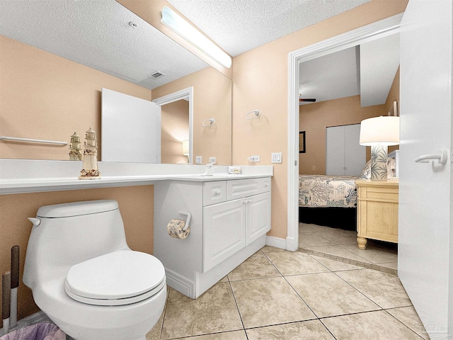 bathroom with vanity, tile patterned floors, a textured ceiling, and toilet