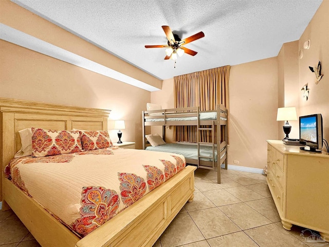 bedroom featuring ceiling fan, a textured ceiling, and light tile patterned floors