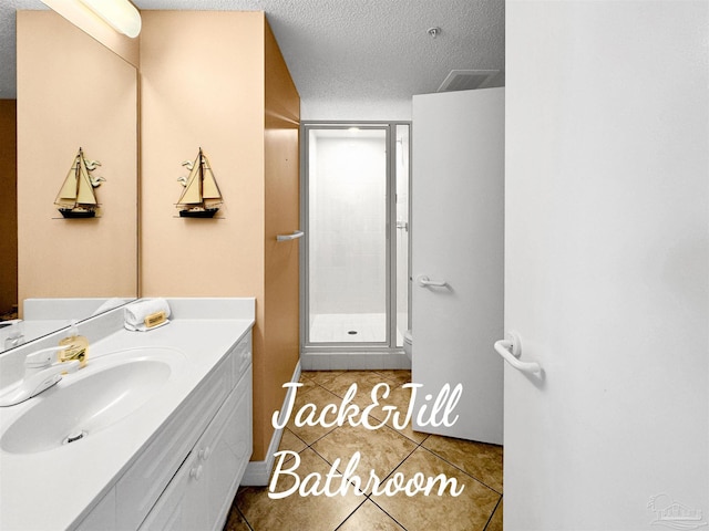 bathroom with vanity, tile patterned floors, a textured ceiling, and walk in shower