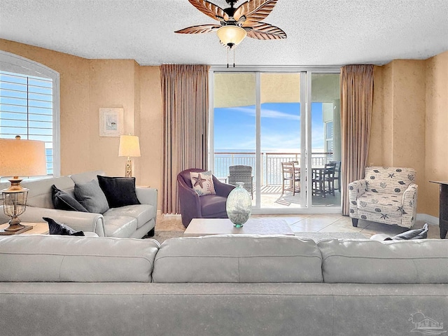 living room featuring expansive windows, a textured ceiling, and a wealth of natural light