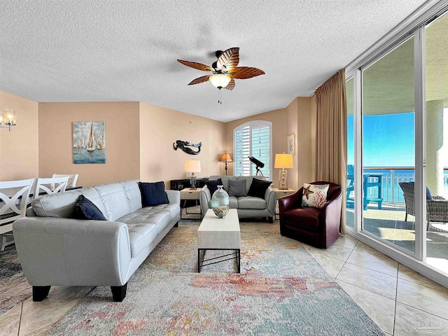 living room with light tile patterned flooring, a textured ceiling, and ceiling fan