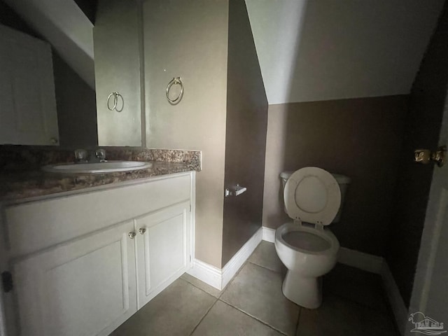 bathroom with toilet, tile patterned flooring, vanity, and baseboards