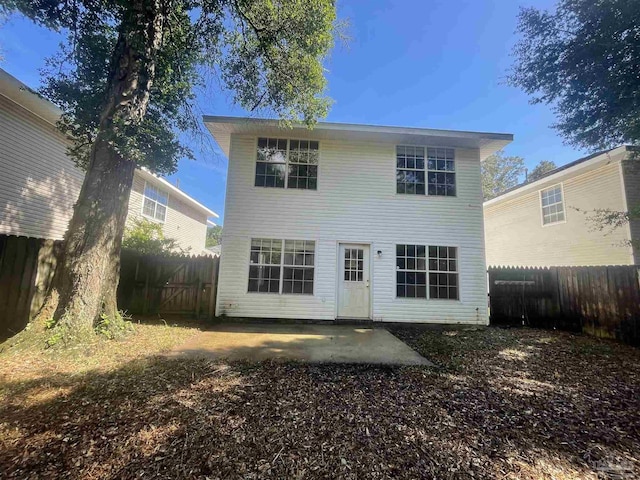 rear view of house featuring a fenced backyard and a patio