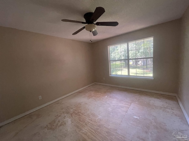 unfurnished room with ceiling fan and baseboards