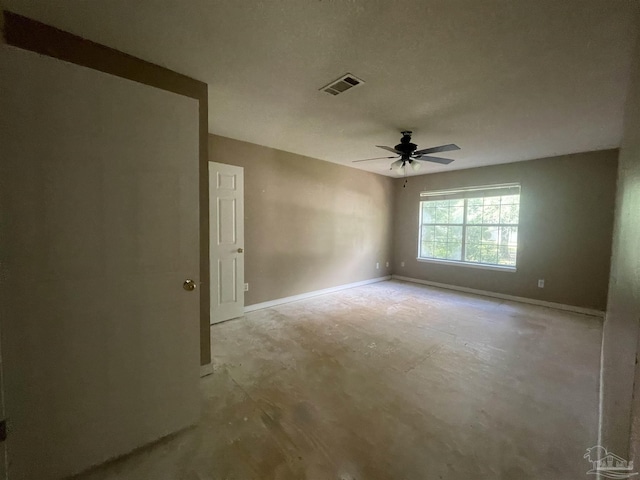 spare room featuring ceiling fan, visible vents, and baseboards