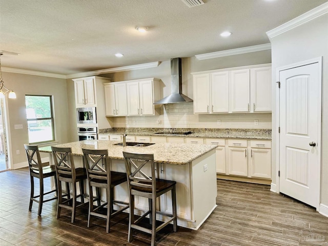 kitchen with a sink, wall chimney exhaust hood, dark wood-style flooring, and stainless steel appliances