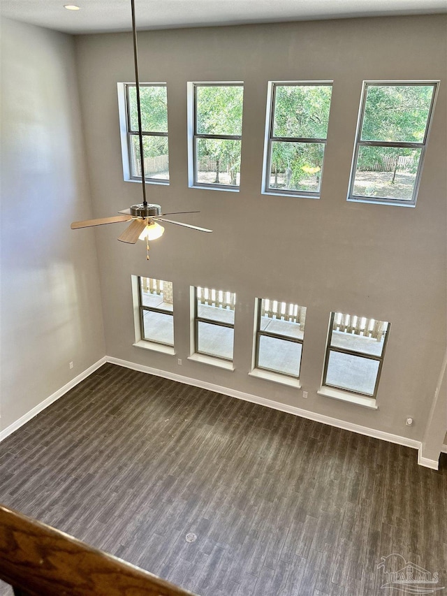 interior space with baseboards, dark wood finished floors, and ceiling fan