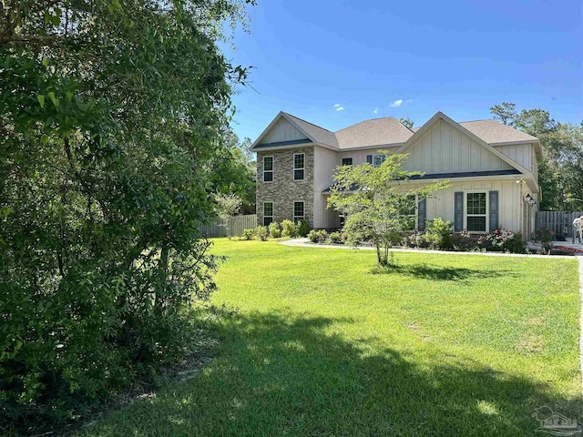 view of front of home featuring a front lawn, board and batten siding, and fence