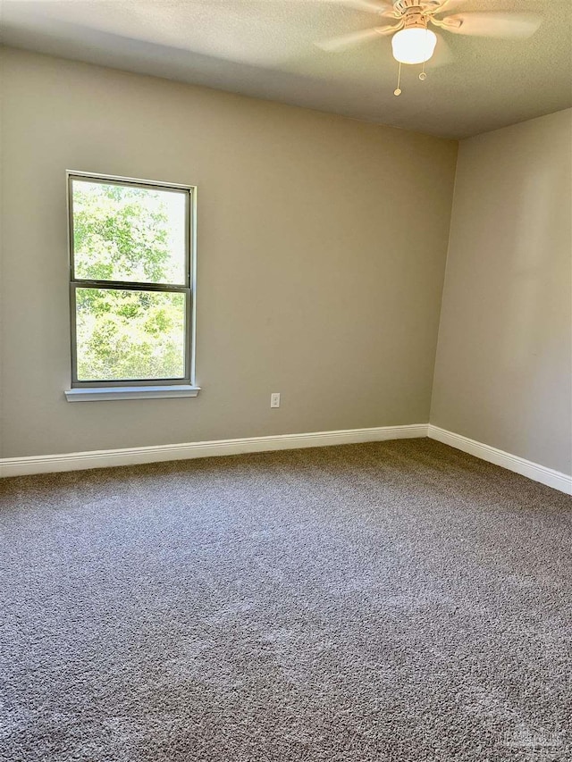 empty room with a ceiling fan, baseboards, and carpet